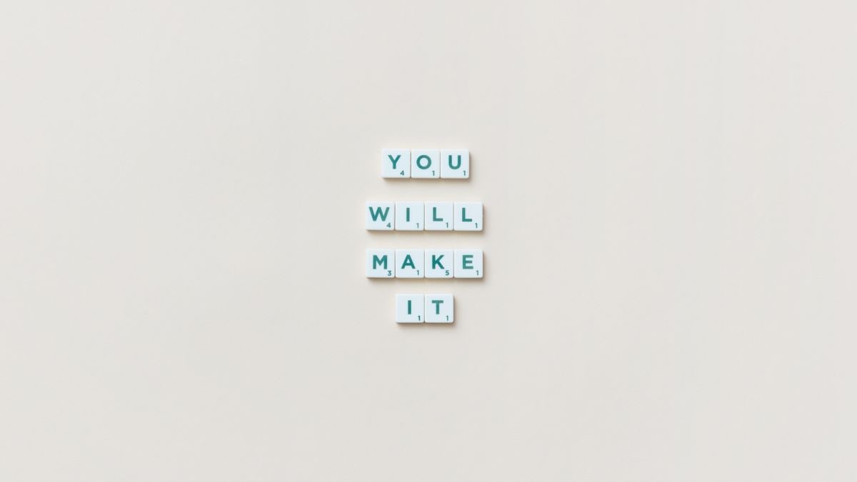 Motivational phrase 'You Will Make It' made from Scrabble tiles on a neutral background.